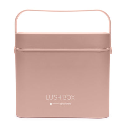 The Rio Lush Box Vanity Case - Large is a square, light pink storage case with a lid and handle, featuring LUSH BOX and the beauty specialists in white—ideal for chic beauty organization.