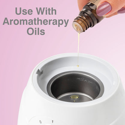 A hand pours aromatherapy oil into the Rio Facial Sauna Skincare with Steam Inhaler – pink, against a pink background, with text: Use With Aromatherapy Oils.
