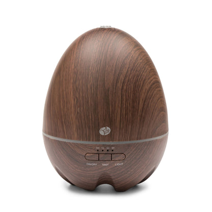 The Rio ARIA Aroma Diffuser Humidifier and Nightlight features a dark wood-grain, egg-shaped design with easy-access front buttons for on/off, mist, and light—perfect for relaxation and décor.